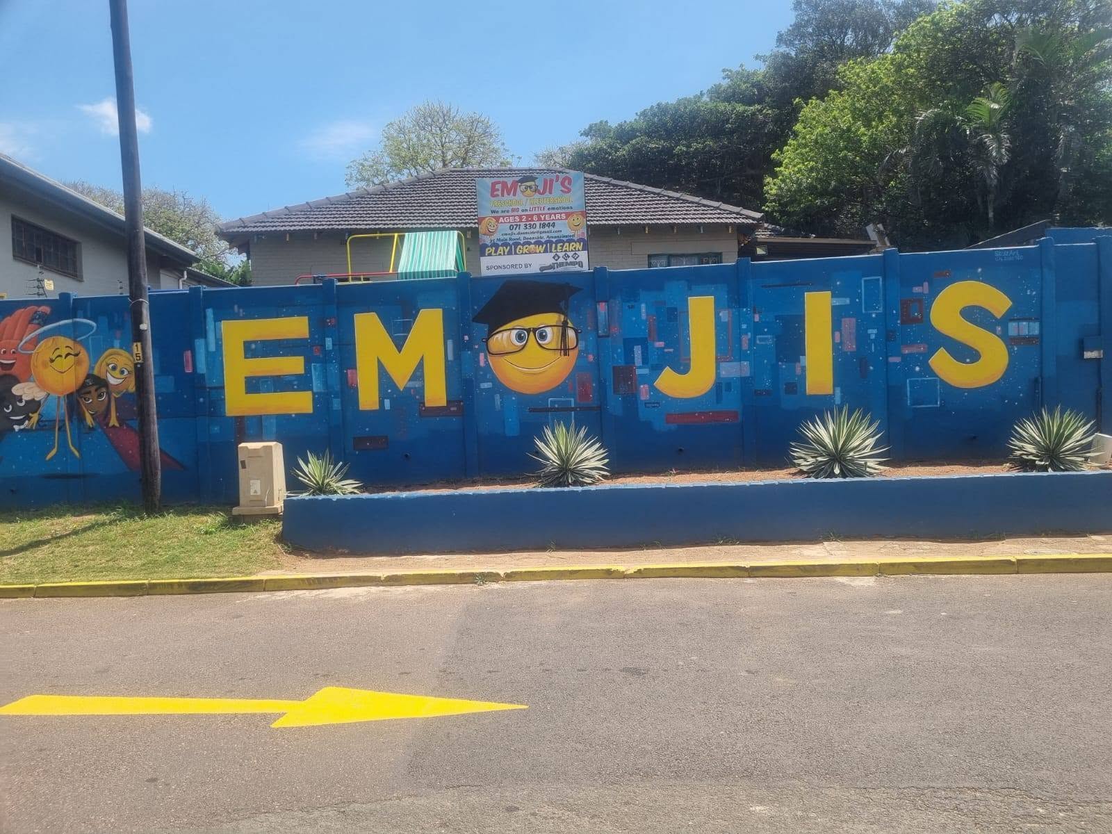 The real Emojis preschool exterior: a blue wall with large yellow letters in Doonside